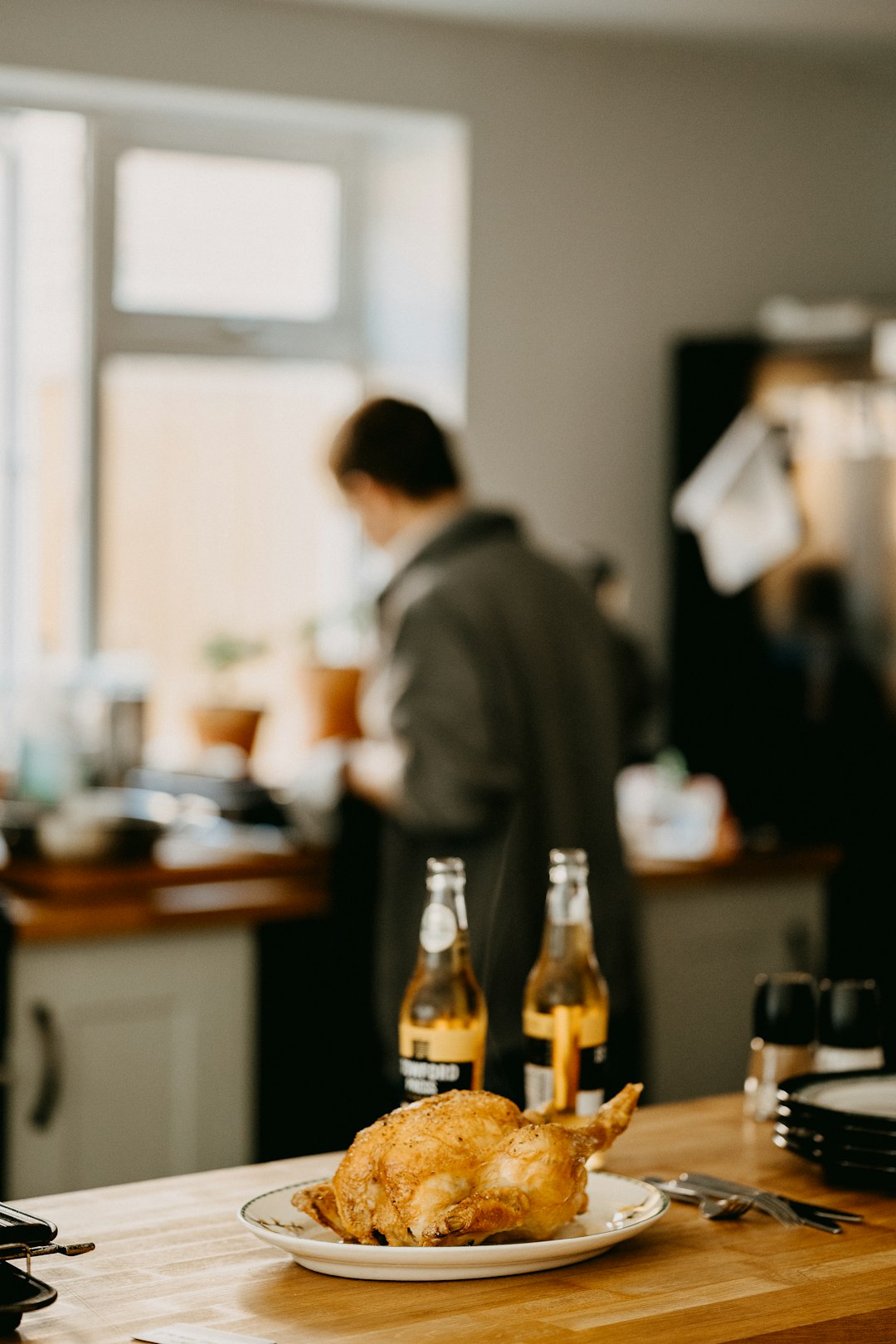 man-in-gray-dress-shirt-standing-in-front-of-table-with-bottles-q5-xb0pfnmk